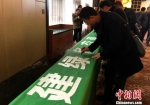 　　1月13日，与会人员签名参与绿色低碳出行。　杨光振 摄 - 贵州新闻