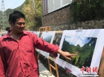 　图为大窝凼的搬迁民众代表杨天豪用手指着照片上曾经自家的位置，讲述移民新生活。　黄蕾瑾 摄 - 贵州新闻