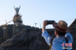 4月22日，一名游客用手机拍下“仰阿莎”雕像。坐落于贵州省剑河县仰阿莎湖畔的苗族美神“仰阿莎”雕像已安装完毕，预计2017年6月底工程全部完工，建成后该雕塑有望成为全国最高的苗族美神雕像。“仰阿莎”雕像于2016年11月开工建设，整座雕像高88米，其中底座高22米，雕像身高66米，取自于当地苗族节日“二月二”和“六月六”，有着苗族传统文化寓意。“仰阿莎”被苗族人民奉为美神，贵州清水江剑河县一带至今仍流传着“仰阿莎”的传说。2008年，“仰阿莎”被列入第二批国家级非物质文化遗产名录。 中新社记者 贺俊怡 摄 - 贵州新闻