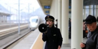 图为吴夏璐拿着扩音器提示旅客站在正确的乘车位置。吴吉斌 摄 - 贵州新闻