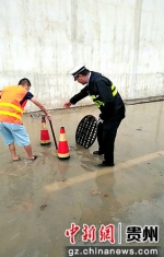 民警和群众在北二环俊发城积水路段疏导、清除下水口处泥沙。 - 贵州新闻