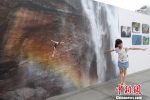 　图为一位小朋友在模仿照片里跳水运动员的动作拍照留念。贺俊怡 摄 - 贵州新闻