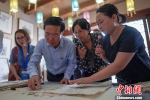 7月22日，武文赏(左二)在遵义花茂村向村民了解古法造纸。 中新社记者 贺俊怡 摄 - 贵州新闻